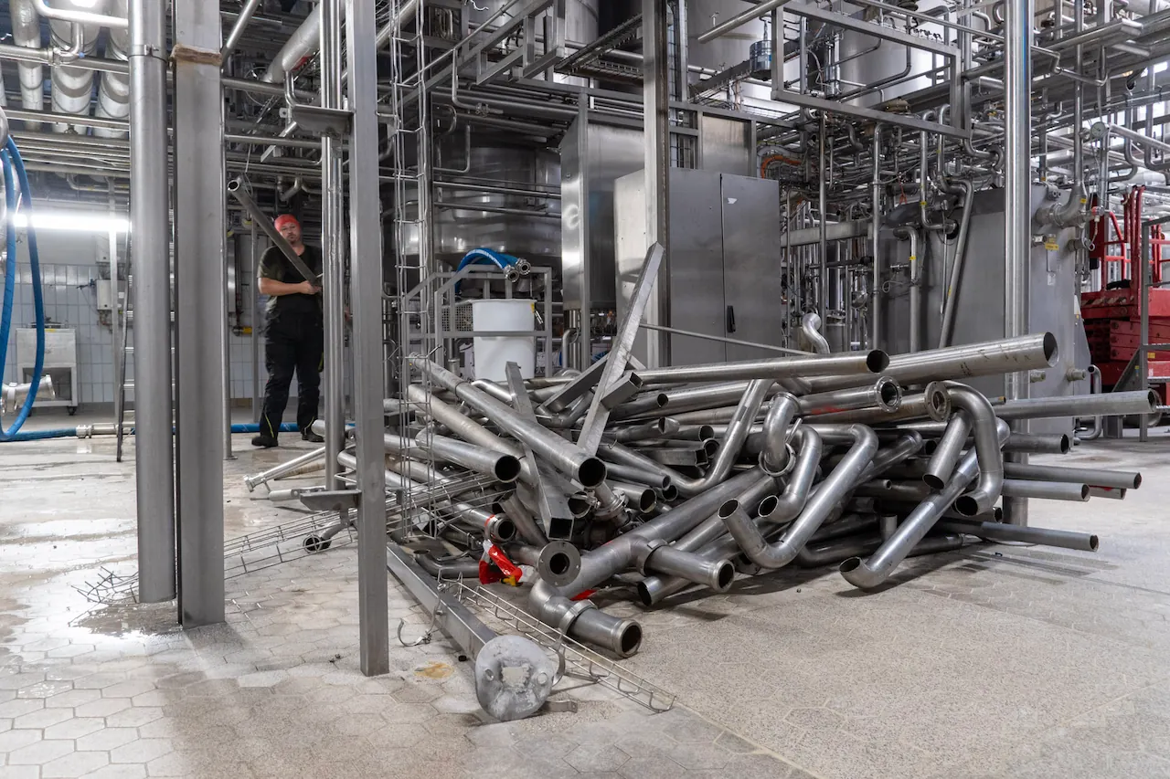 Demontierte Edelstahlrohre und Rohrleitungen in einer Industrieanlage während einer professionellen Industriedemontage